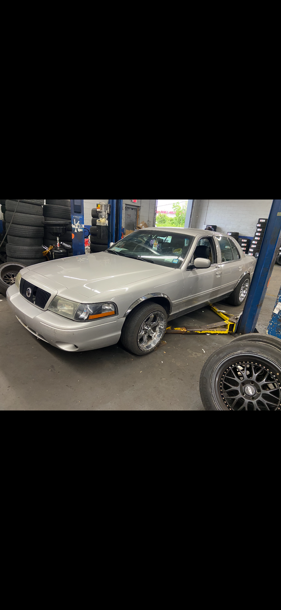 Mercury Grand Marquis on lift getting wheel and tire work